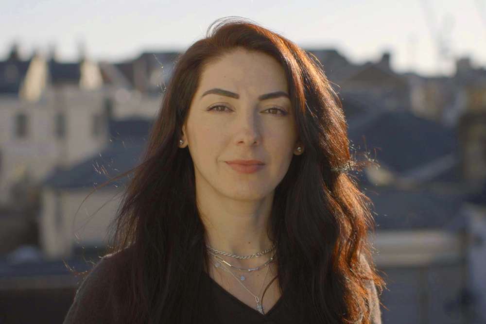 A dark-haired woman, smiling.