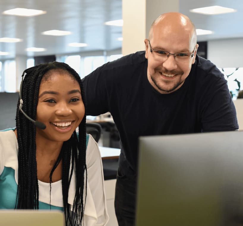 Support accountants Ope and Stuart looking at a computer screen together.
